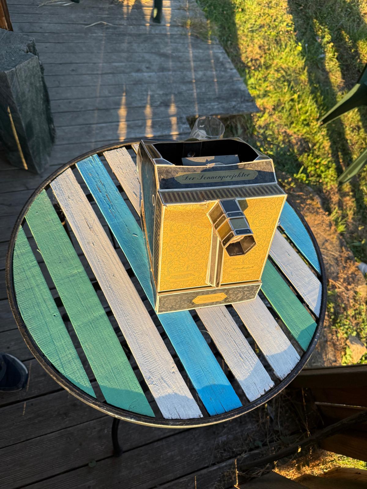 Sonnenprojektor aus geprägtem Karton auf einem Gartentisch
