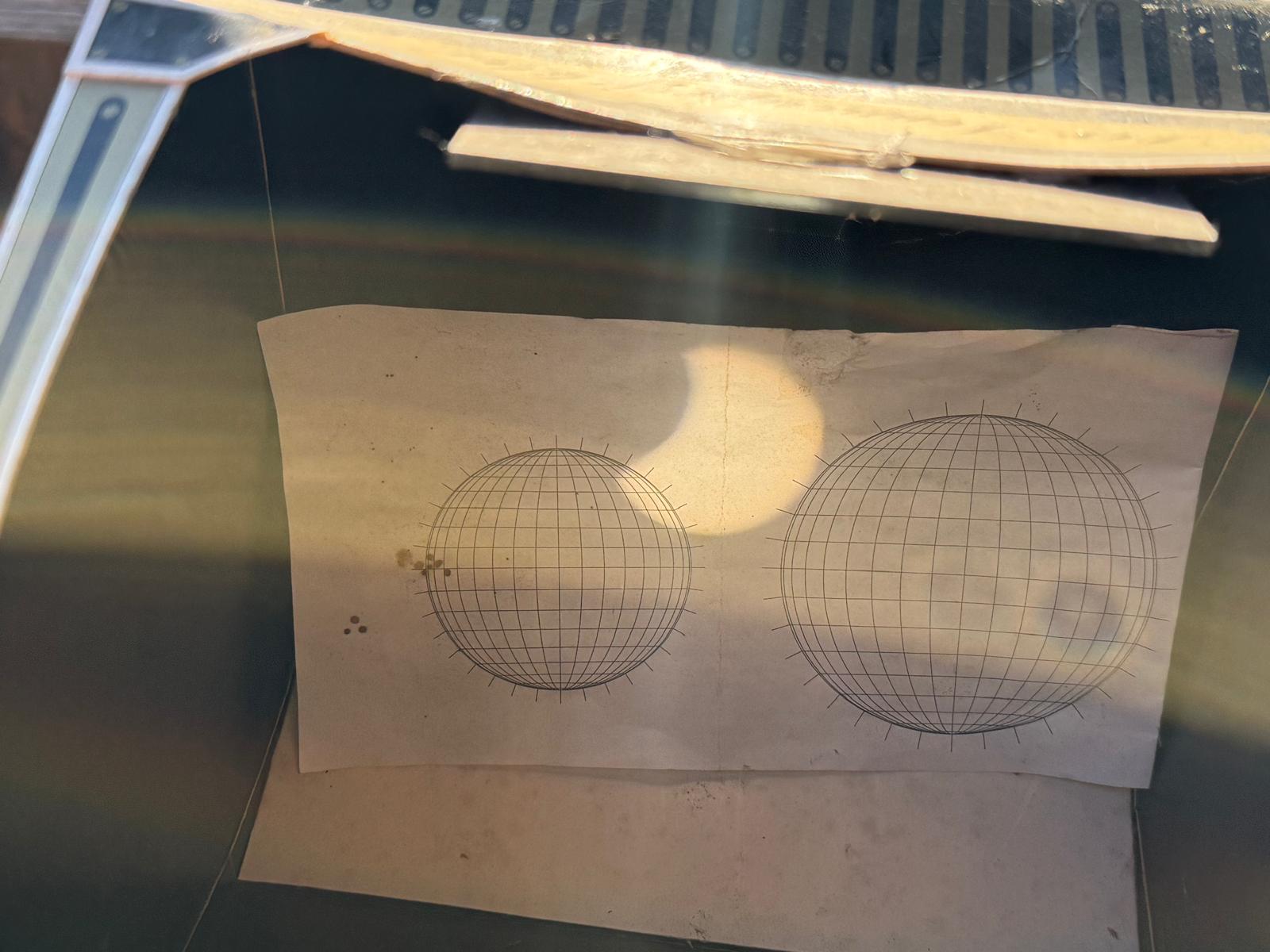 Projiziertes Bild der Sonnensichel auf einem Blatt mit gerasterten Sonnenscheiben